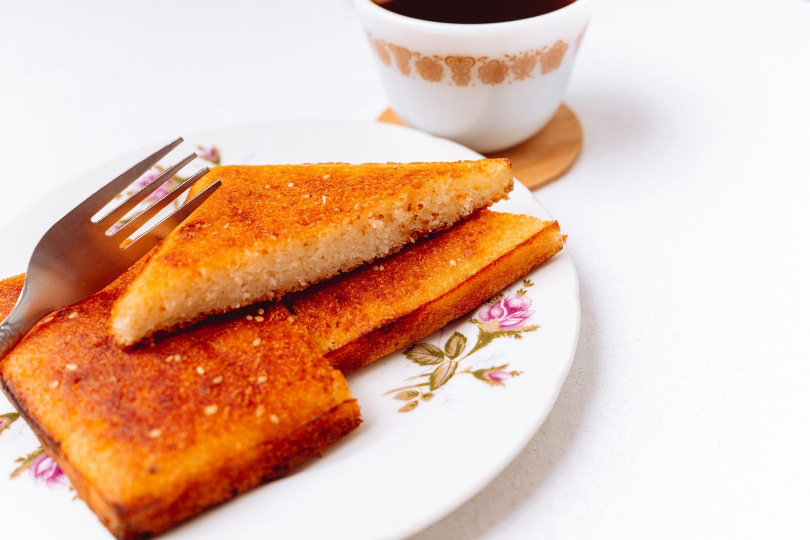 a white plate topped with french toast next to a cup of coffee